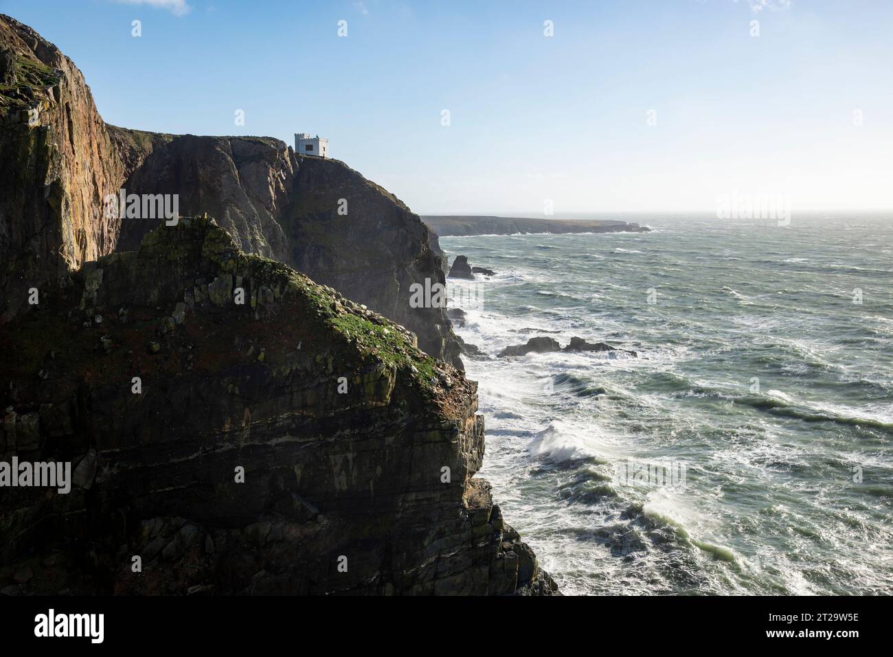 Elin's Tower eine Torheit am Rande der dramatischen Klippen in South Stack, Anglesey, Nordwales. Ein windiger Herbsttag mit Wellen, die gegen Felsen krachen. Stockfoto