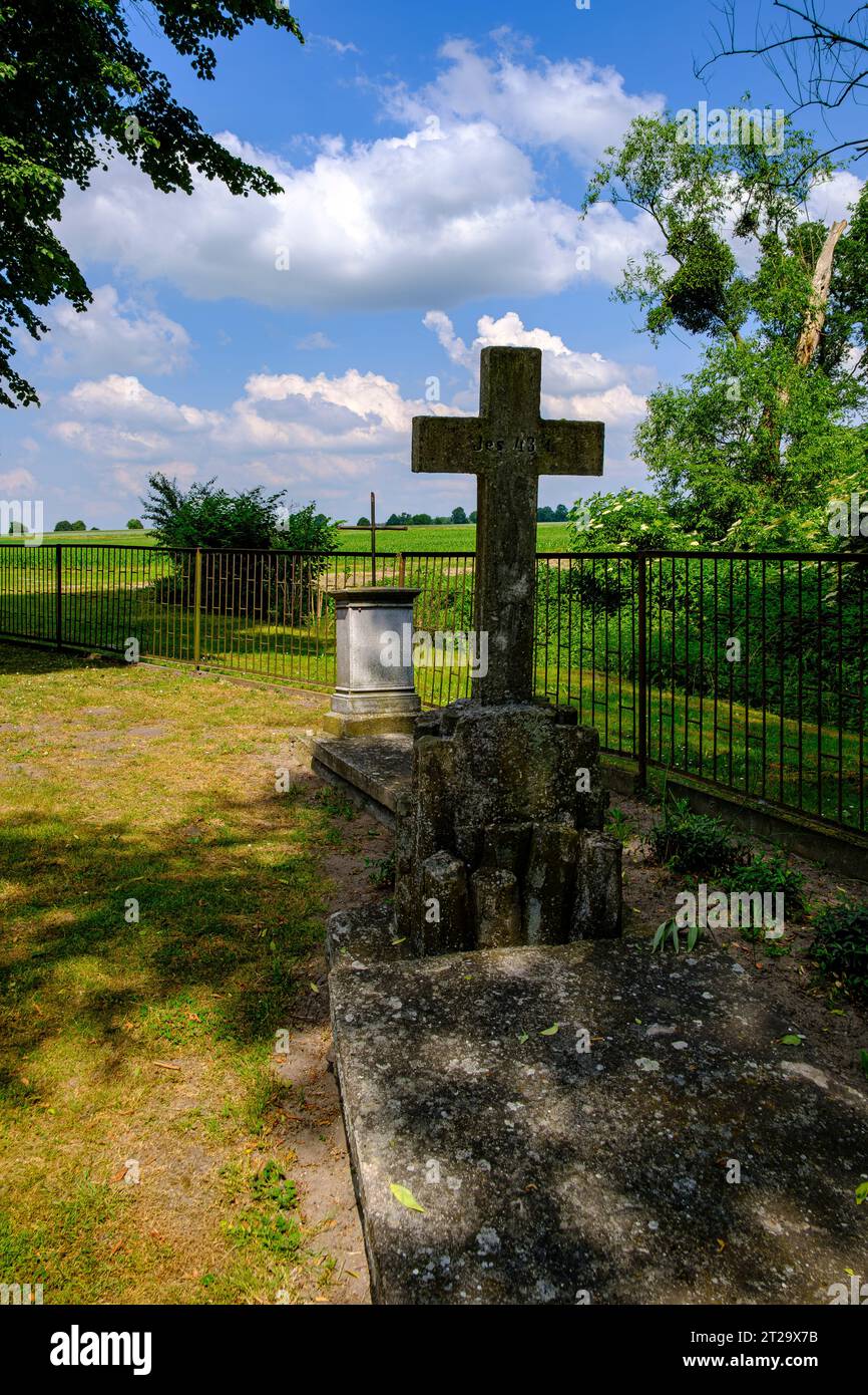 Historisches Grab mit Steinkreuz auf dem Friedhof der Rohholzkirche von 1788 in Roznow (Rosen), Woiwodschaft Opole, Polen. Stockfoto