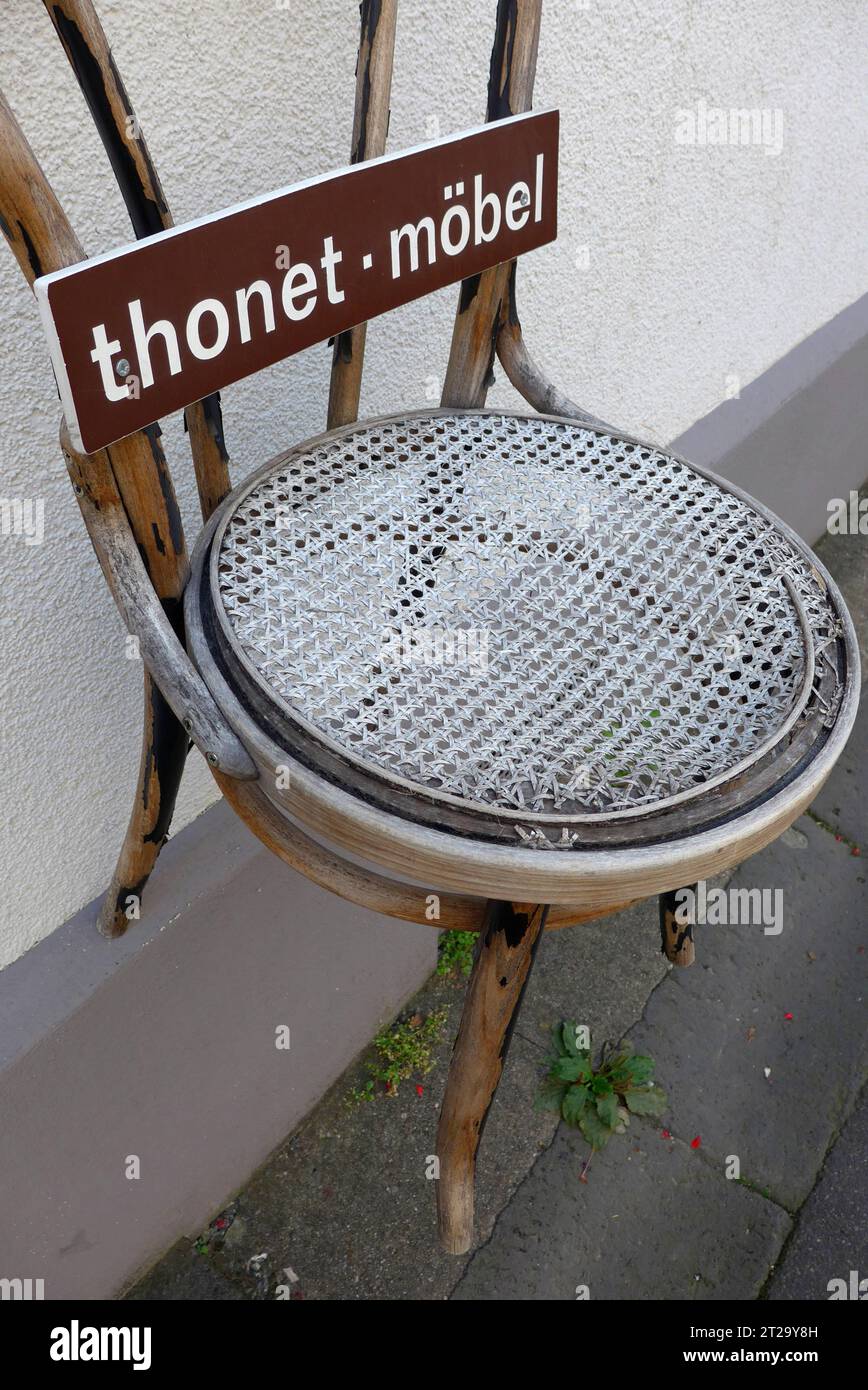 Klassischer Holzstuhl der Firma Thonet, aufgehängt an der Hausfassade eines Antiquitätenhändlers in Boppard am Rhein Rheinland-Pfalz. Der Gründer des Familienunternehmens Thonet, Michael Thonet 1796–1871, war ein deutsch-österreichischer Tischlermeister, der zunächst eine Tischlerei in Boppard betrieb. 1842 zog er nach Wien. Seit 1953 hat die Thonet GmbH ihren Hauptsitz in Frankenberg Hessen. Kaffeehausstühle von Thonet gilt als Designklassiker. *** Klassischer Holzstuhl der Firma Thonet, hing an der Fassade eines Haus Antiquitätenhändlers in Boppard an der Rheinland-Pfalz der Foun Stockfoto