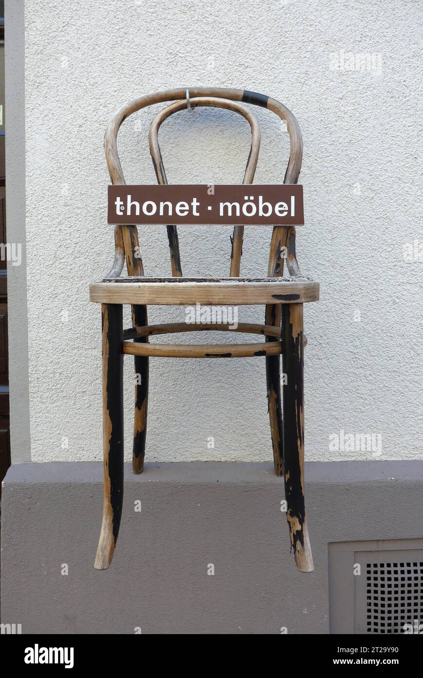 Klassischer Holzstuhl der Firma Thonet, aufgehängt an der Hausfassade eines Antiquitätenhändlers in Boppard am Rhein Rheinland-Pfalz. Der Gründer des Familienunternehmens Thonet, Michael Thonet 1796–1871, war ein deutsch-österreichischer Tischlermeister, der zunächst eine Tischlerei in Boppard betrieb. 1842 zog er nach Wien. Seit 1953 hat die Thonet GmbH ihren Hauptsitz in Frankenberg Hessen. Kaffeehausstühle von Thonet gilt als Designklassiker. *** Klassischer Holzstuhl der Firma Thonet, hing an der Fassade eines Haus Antiquitätenhändlers in Boppard an der Rheinland-Pfalz der Foun Stockfoto