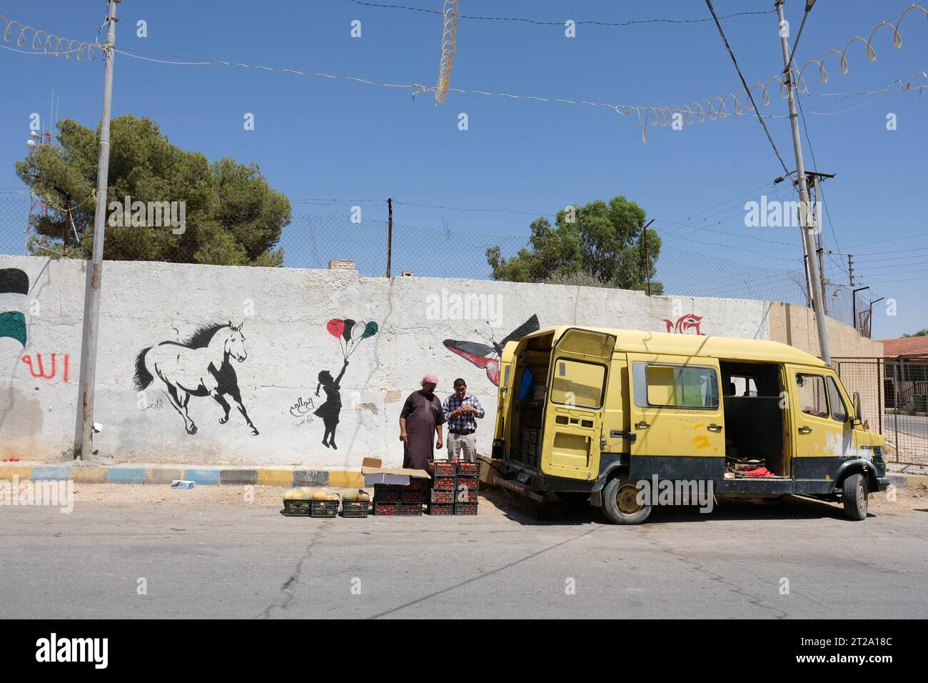 Dhiban Jordan Street Art im Stil von Banksy an einer Wand in der kleinen Stadt Dhiban neben Obst- und Gemüsehändler im August 2023 Stockfoto