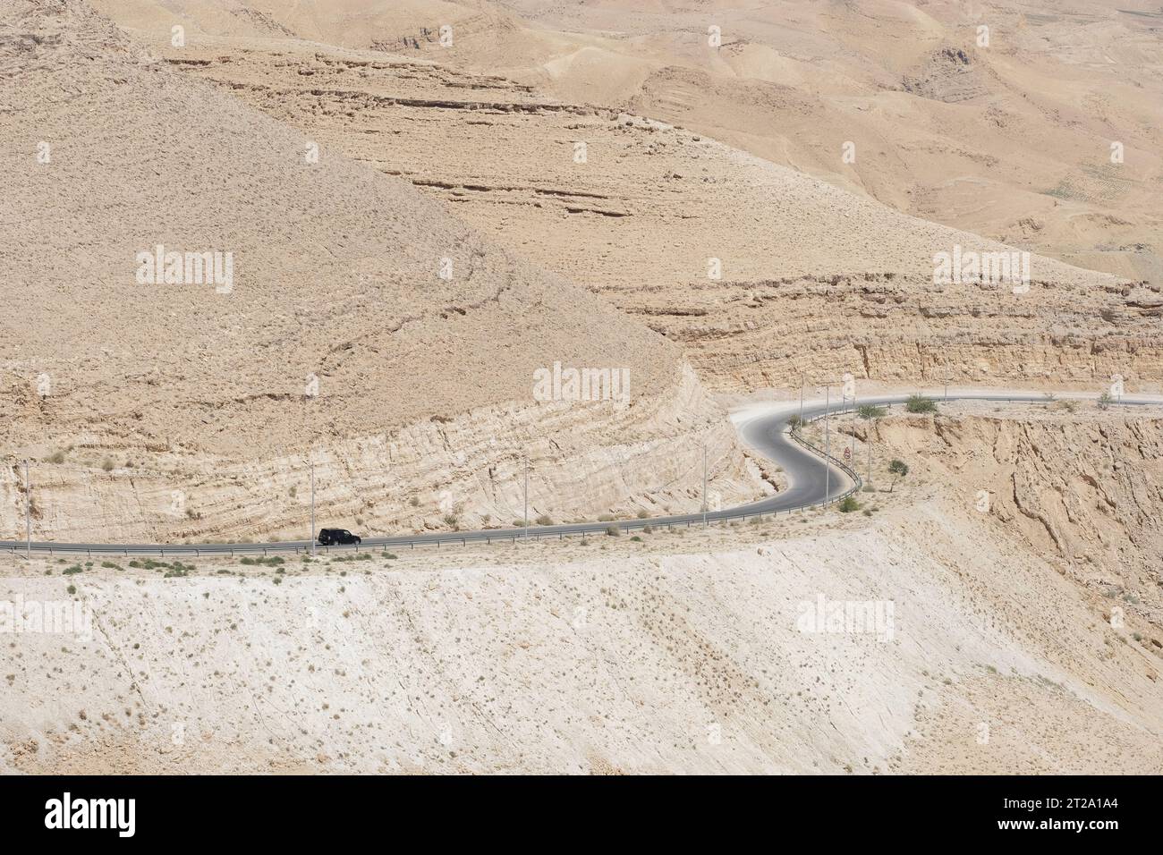Ein einsamer Wagen auf dem Kings Highway überquert im August 2023 das Wüstengebiet Jordaniens nahe Wadi Al Mujib Stockfoto