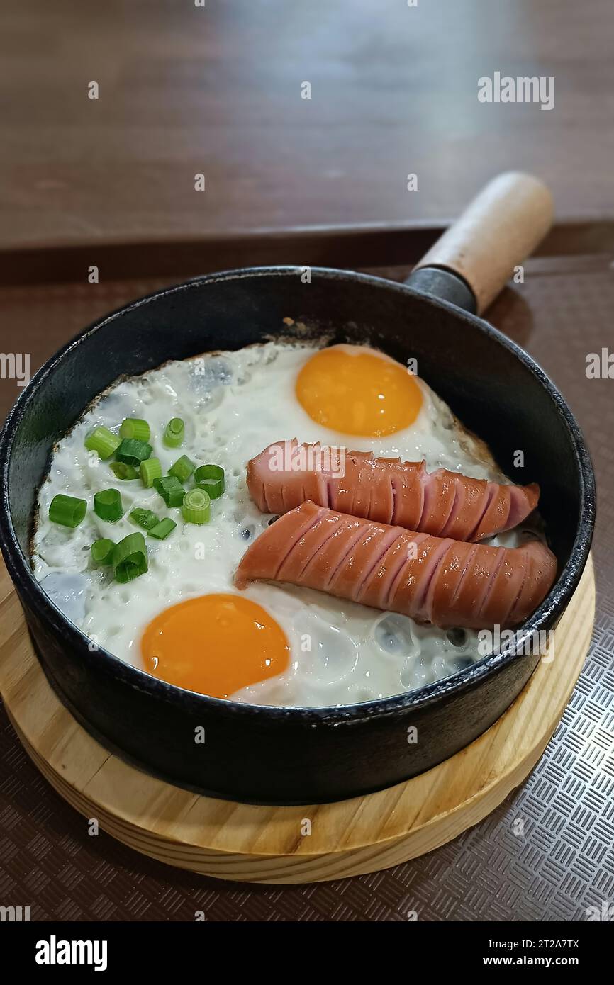 Rührei in einer Pfanne mit frittierten Würstchen in einem Restaurant Stockfoto