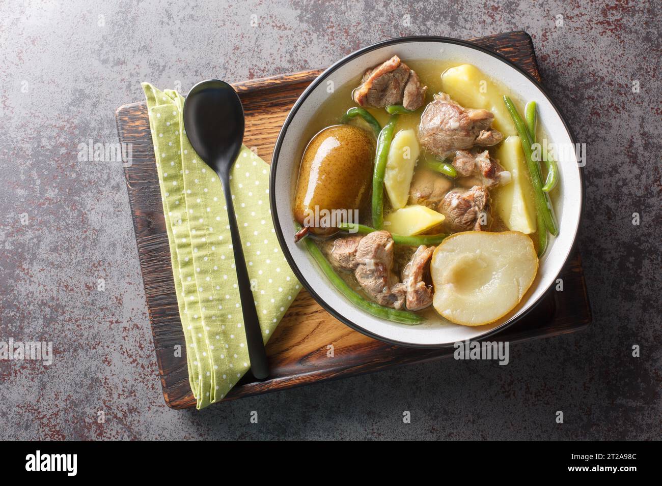 Schwedischer Lammeintopf mit frischen Birnen, Kartoffeln, grünen Bohnen in einer Schüssel auf einem Holzbrett. Horizontale Draufsicht von oben Stockfoto