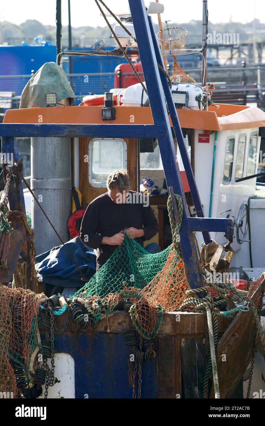 Fisherman repariert seine Fischernetze in Harwich Harbour. Stockfoto