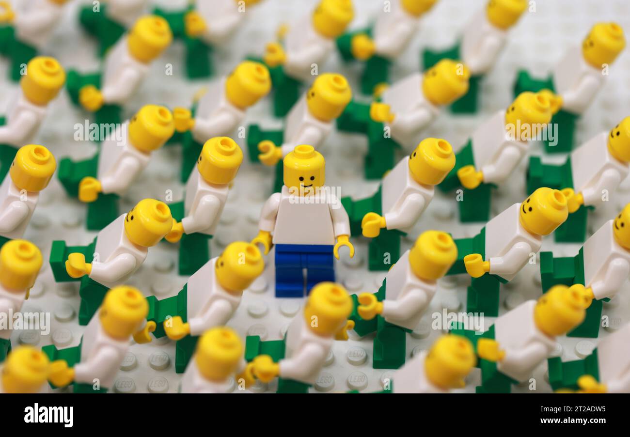 Ein Mann, der sich in einer anderen Hose verkleidet, in der Menge kahlköpfiger Menschen und herausragend wird Stockfoto