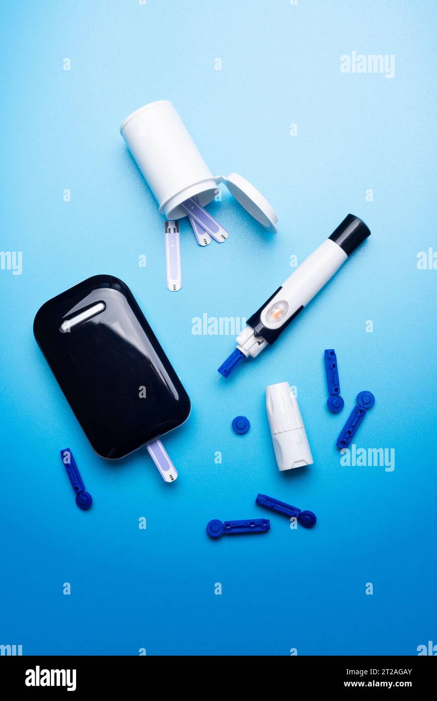 Diabetes-Awareness-Konzept von Blutzuckermessstreifen und Lanzetten auf blauem Hintergrund Stockfoto