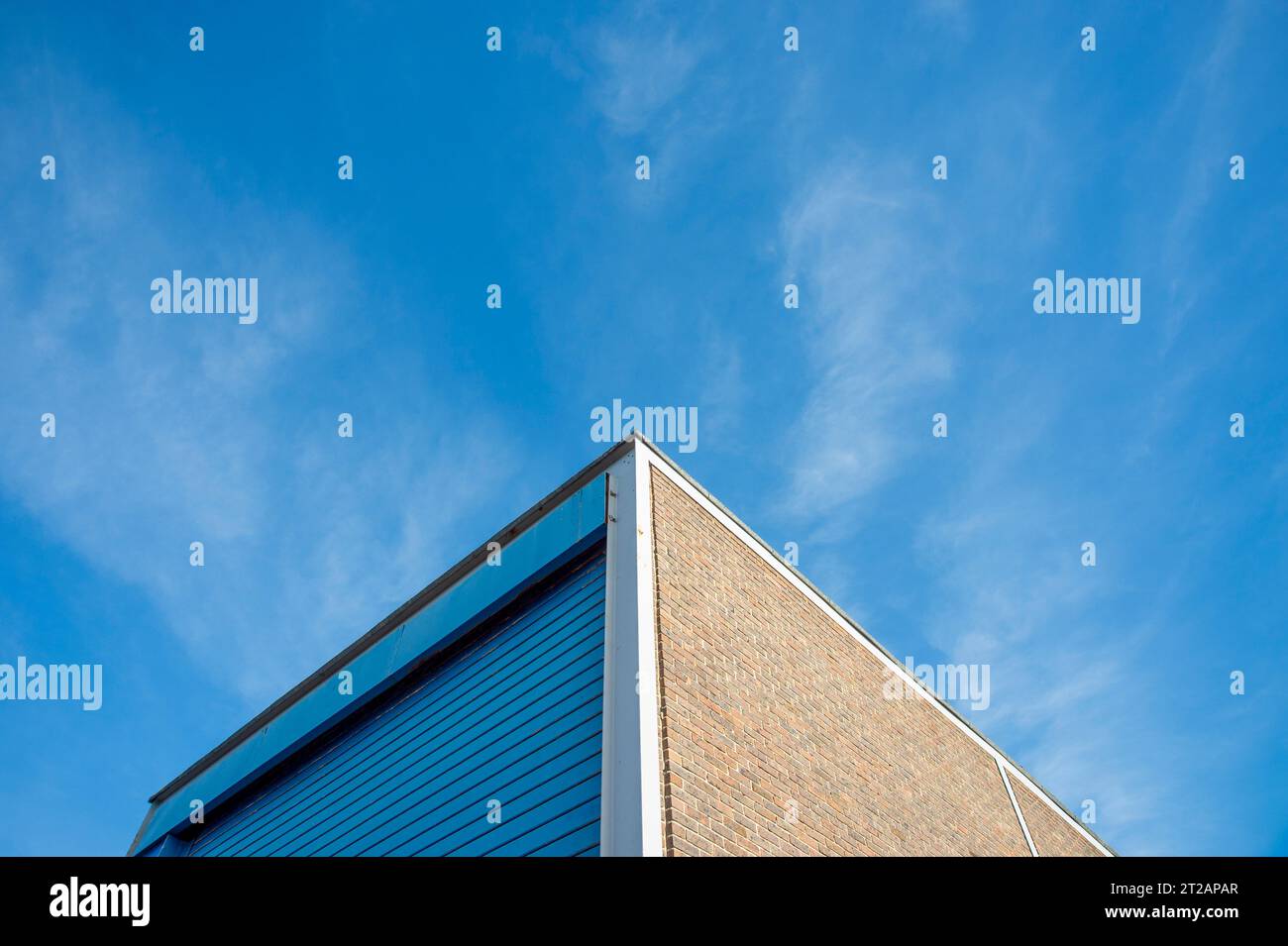 Lagereinheit für den Industriebau mit Rolltor vor blauem Himmel Stockfoto