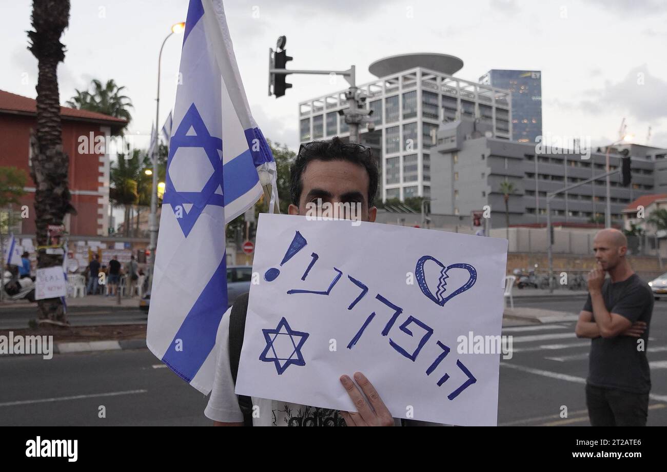 Ein israelischer Zivilist hält die israelische Flagge und ein Schild mit der Aufschrift "Wir wurden verlassen" als Unterstützer und Familienmitglieder israelischer Geiseln, die letzte Woche von der militanten palästinensischen Gruppe Hamas geschnappt wurden. Protest vor dem Militärstützpunkt HaKirya, der das Hauptquartier des israelischen Verteidigungsministeriums und Büros des IDF-Generalstabs beherbergt, am 16. Oktober 2023 in Tel Aviv, Israel. Stockfoto