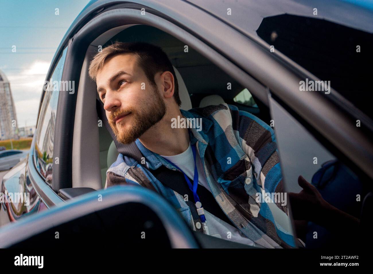 Junger bärtiger Passagier, der aus dem Fenster eines Autos blickt. Reise, Lifestyle, Verkehrskonzept Stockfoto