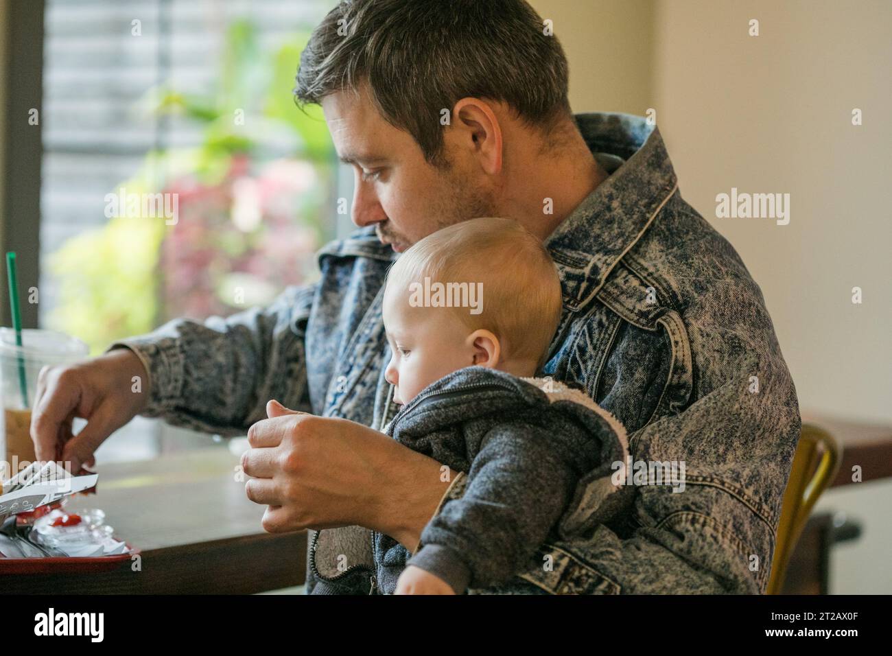 Kind ist ein wählerischer Esser in Restaurant und Vater versucht, es zu füttern Stockfoto