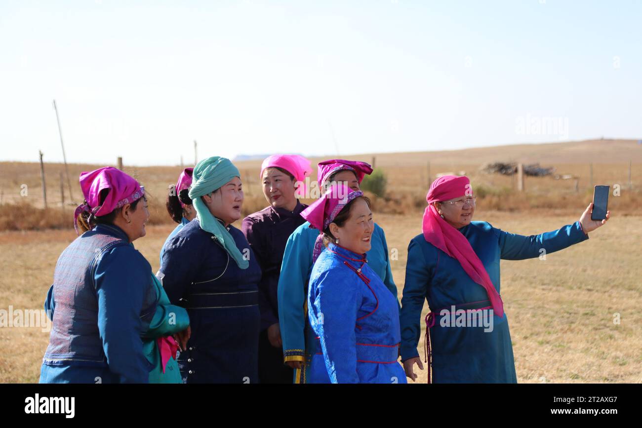 (231018) -- ORDOS, 18. Oktober 2023 (Xinhua) -- Mitglieder einer Band "Nair" bereiten sich vor, Gruppenfotos während der Auftritte auf einem Grasland in Otog Banner of Ordos, Nordchinas Autonomer Region Innere Mongolei, 16. Oktober 2023 zu machen. Dorji ist ein 61-jähriger Hirte, der in Otog Banner lebt. Während der Herbstsaison gehört Dorjis tägliche Routine zum Hüten von Pferden und Ziegen. Er hat über 200 Arabas Kaschmirziegen, die eine solide wirtschaftliche Rendite bieten. In seiner Freizeit nimmt Dorji mit seinem 91-jährigen Vater Mingan-erdeni an einer lokalen kulturellen Aktivität namens „Nair“ Teil. „Nair“ geht zurück auf Stockfoto