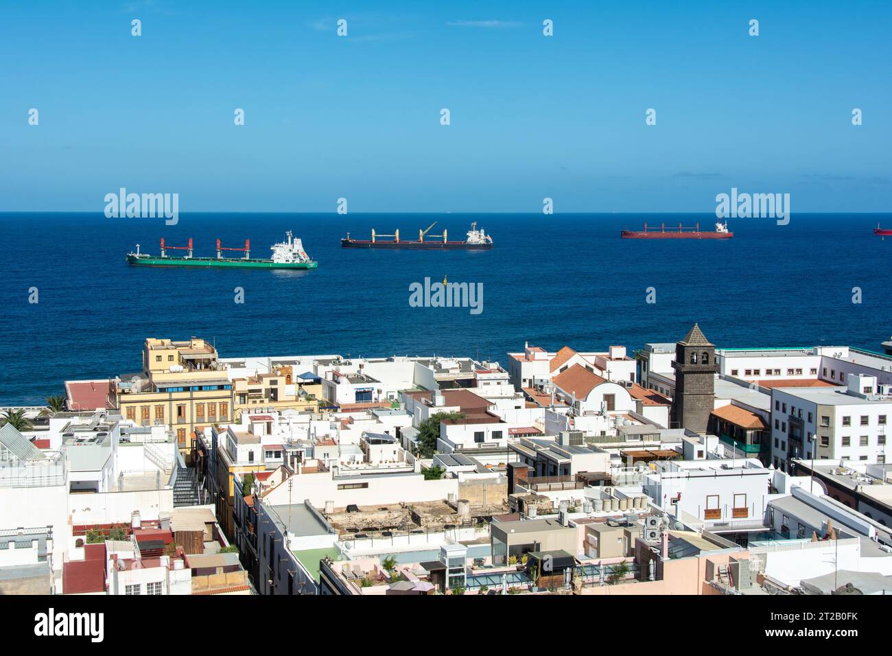 Frachter im Meer mit Dächern der Stadt Las Palmas Gran Canaria, Spanien im Vordergrund Stockfoto