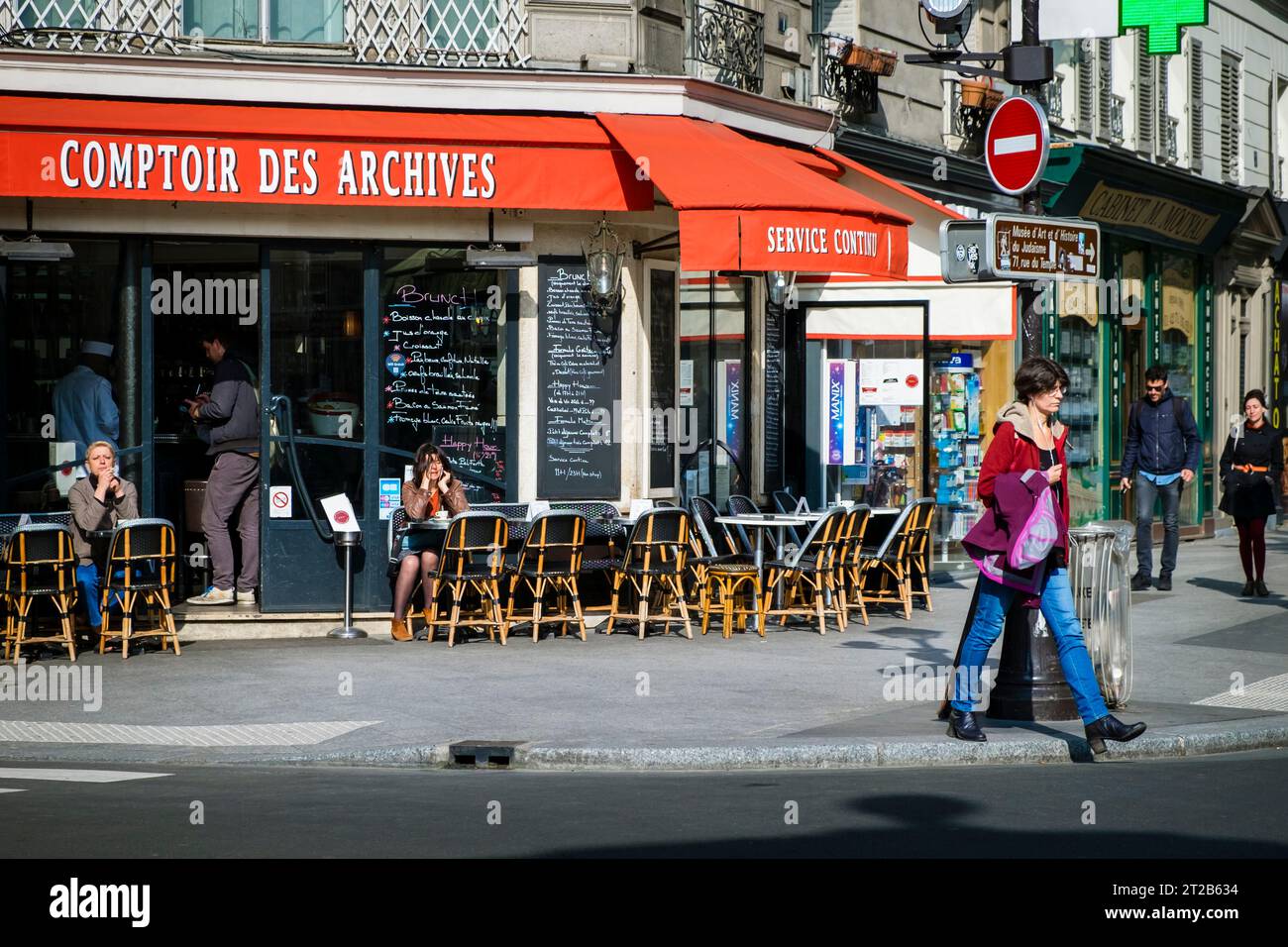 Menschen, die in einem Restaurant im Freien im Viertel Le Marais in Paris, Frankreich, spazieren gehen und sitzen. Stockfoto