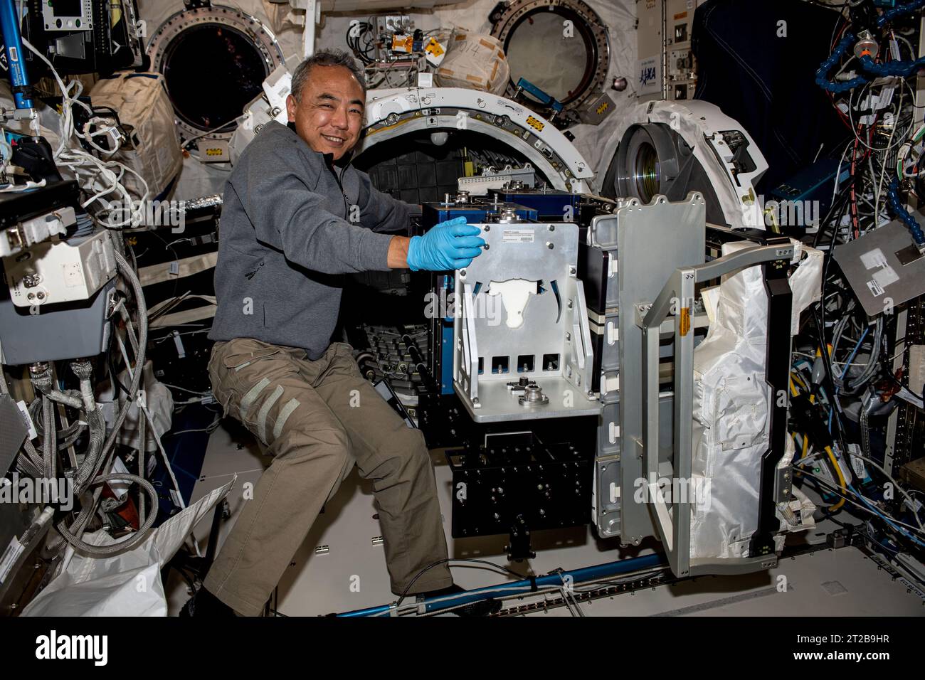 Der JAXA-Astronaut und der Expedition 70-Flugingenieur Satoshi Furukawa entfernt am 29. September 2023 ein Experiment zur Materialexposition aus der Luftschleuse des Kibo-Labormoduls an Bord der Internationalen Raumstation. Stockfoto