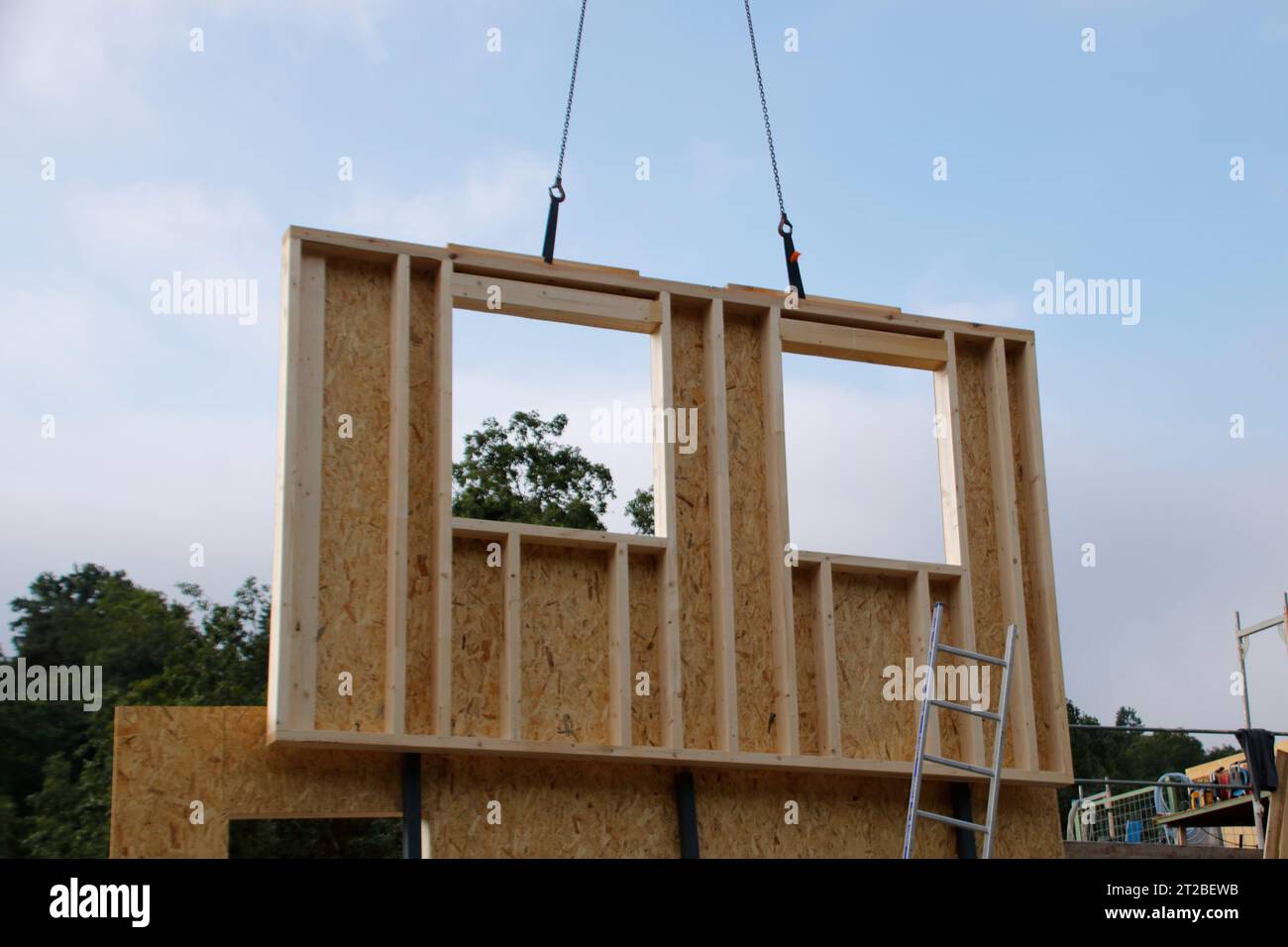 Die Wand mit Fenster eines Fertighauses wird mit einem Kran gebaut Stockfoto