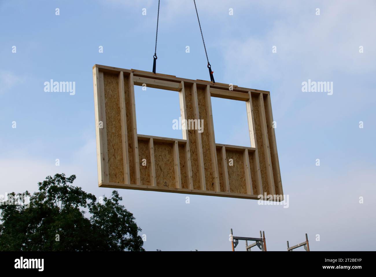 Die Wand mit Fenster eines Fertighauses wird mit einem Kran gebaut Stockfoto