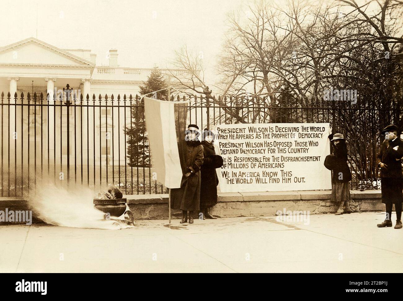 National Woman's Party Watchfire Demonstranten stehen mit Spruchbannern und Feuer in der Urne vor dem Weißen Haus, Washington, D.C., USA, Harris & Ewing, Januar 1919 Stockfoto