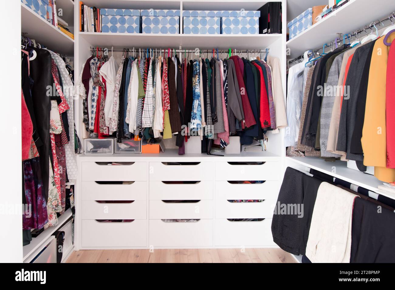 Ein wandelnder Kleiderschrank voller Frauenkleidung. Weiße Holzmöbel Stockfoto