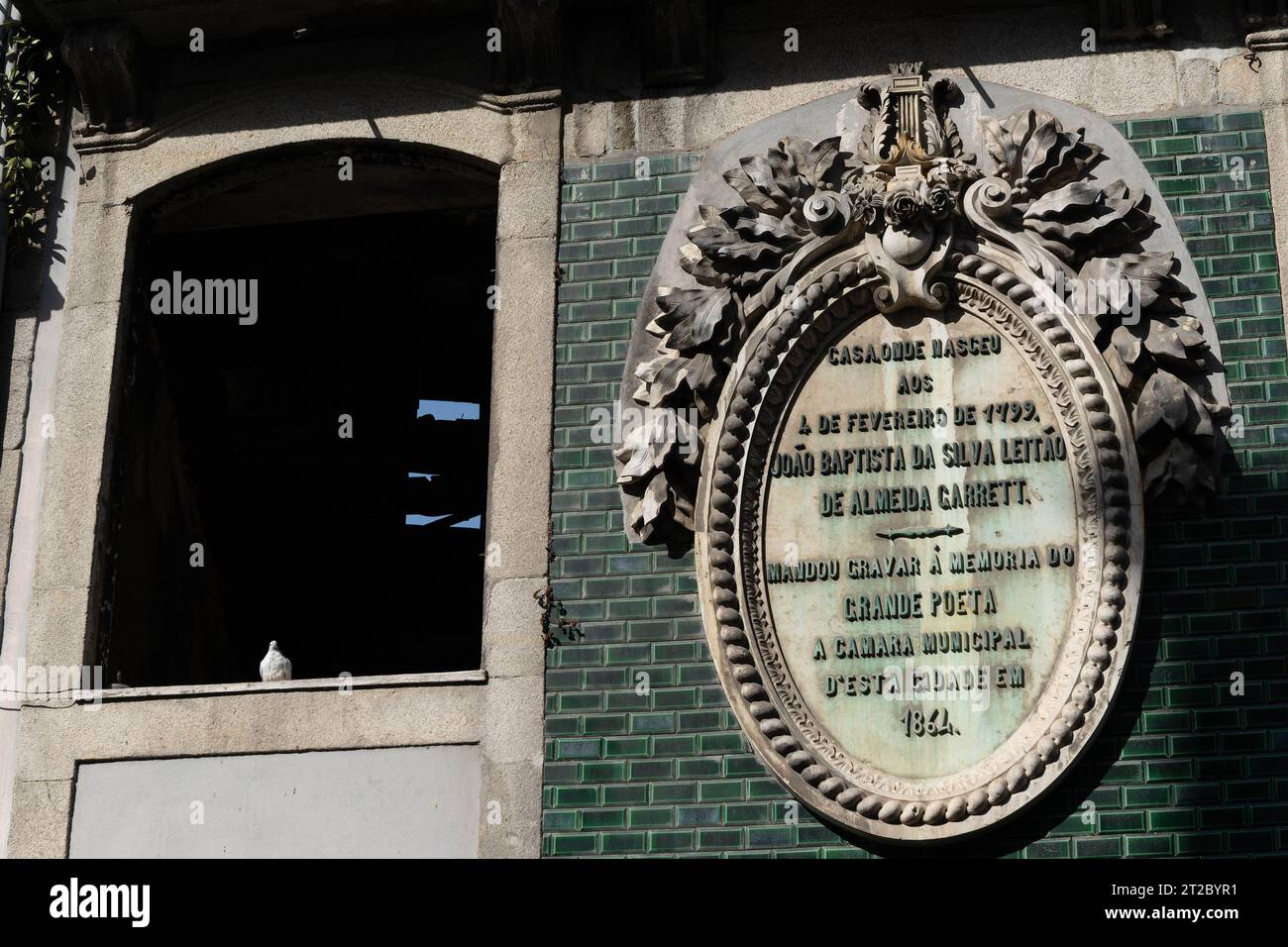 Historische Gedenktafel an der grün gekachelten Gebäudefassade in Porto Stockfoto
