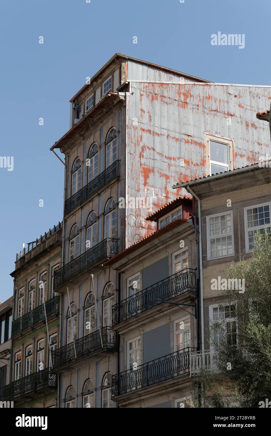 Historische portugiesische Gebäude mit verwittertem Wellblechdach und traditionellen Balkonen im Stadtzentrum von Porto Stockfoto
