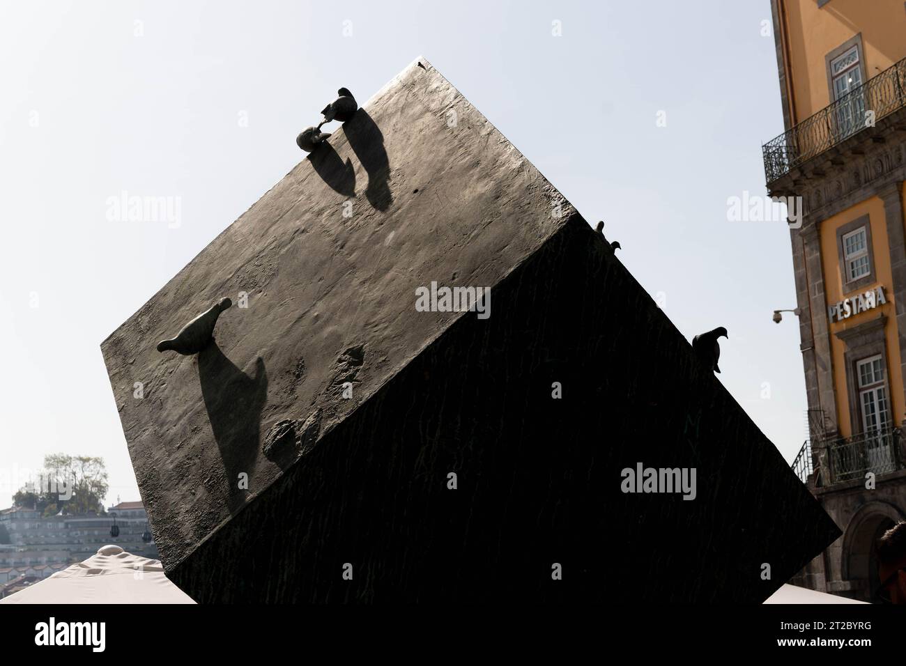 Große, geneigte Betonskulptur mit Menschen, die im Stadtzentrum von Porto auf die Spitze klettern Stockfoto