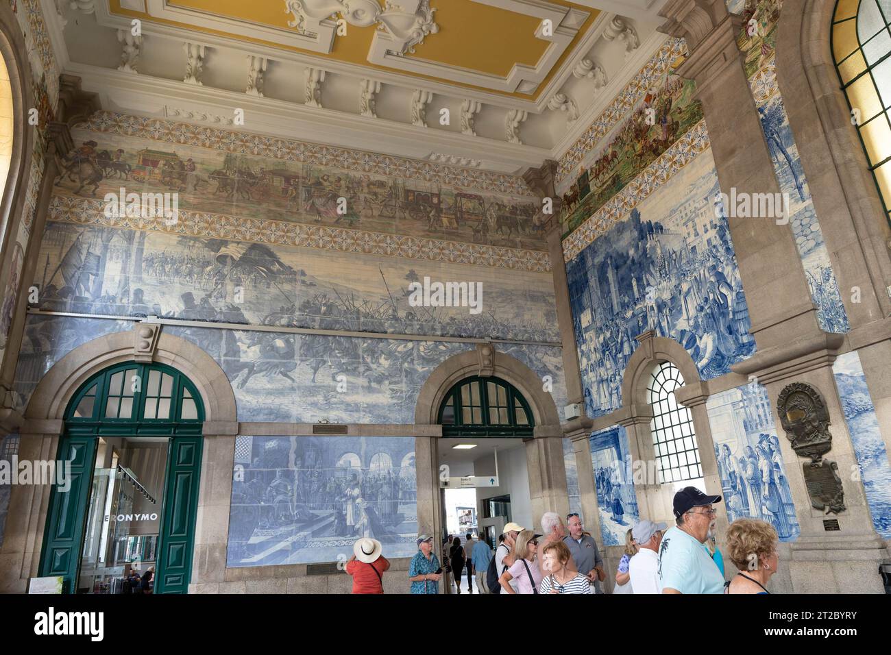 Atemberaubende Wandmalereien mit Azulejo-Fliesen und verzierte Decke im historischen Bahnhof Porto Stockfoto
