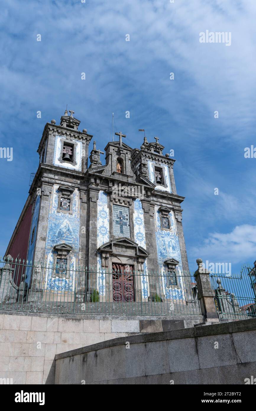 Historische portugiesische Kirche mit verzierten blauen Azulejo-Fliesen vor dem bewölkten Himmel in Porto Stockfoto