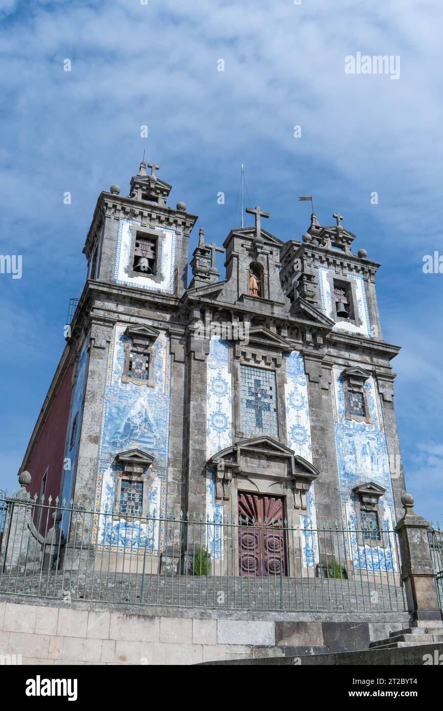 Historische portugiesische Kirche mit verzierten blauen Azulejo-Fliesen und zwei Glockentürmen vor bewölktem Himmel Stockfoto