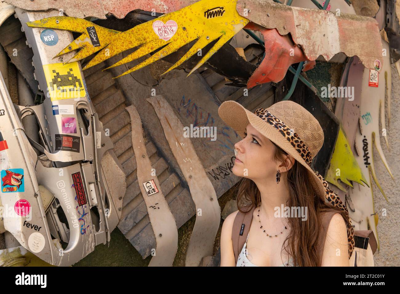 Frau mit Leopardenmuster, die Graffiti-Wand in urbaner Umgebung untersucht Stockfoto