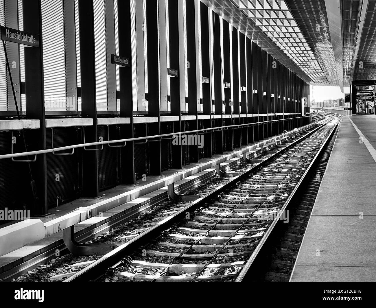 Ein Bahnhof mit einem einzigen Gleis, das sich in der Ferne erstreckt, in Graustufen Stockfoto