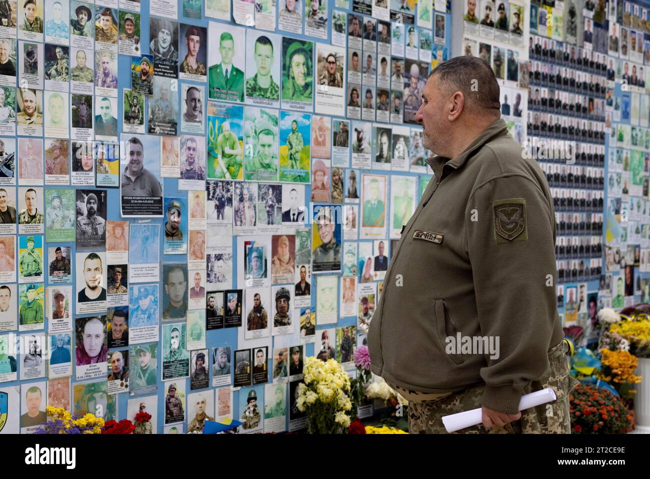 Kiew, Ukraine. Oktober 2023. Ein Soldat sieht sich die Porträts tausender gefallener Soldaten an, die an der Außenwand der St. Michaels Kloster mit goldener Kuppel im Zentrum von Kiew. Das tägliche Leben der Ukrainer, die im Krieg leben. Der russisch-ukrainische Krieg brach aus, als Russland am frühen Morgen des 24. Februar 2022 Raketen auf Kiew abfeuerte. Der Krieg zieht sich seit anderthalb Jahren hindurch, und es gibt keinen Anblick, bald zu enden. (Foto: Hesther ng/SOPA Images/SIPA USA) Credit: SIPA USA/Alamy Live News Stockfoto