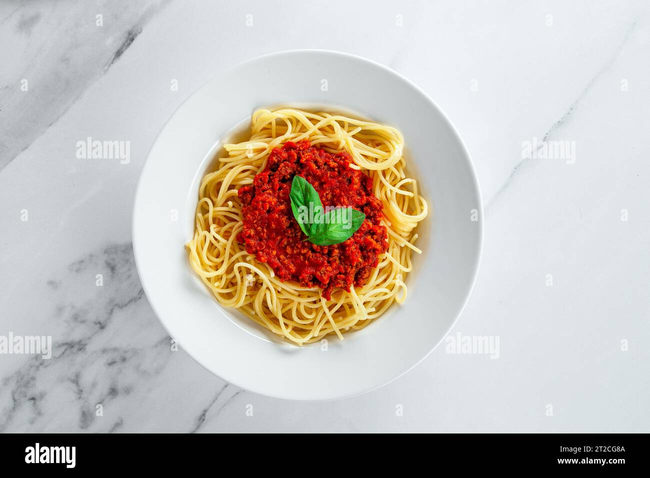 Horizontaler italienischer Spaghetti-Pasta-Noodle-Essteller auf hellem weißen Marmor-Küchentisch Stockfoto