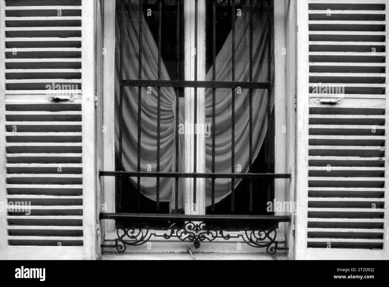 Fenster mit Fensterläden und Vorhängen in Paris, Frankreich Stockfoto