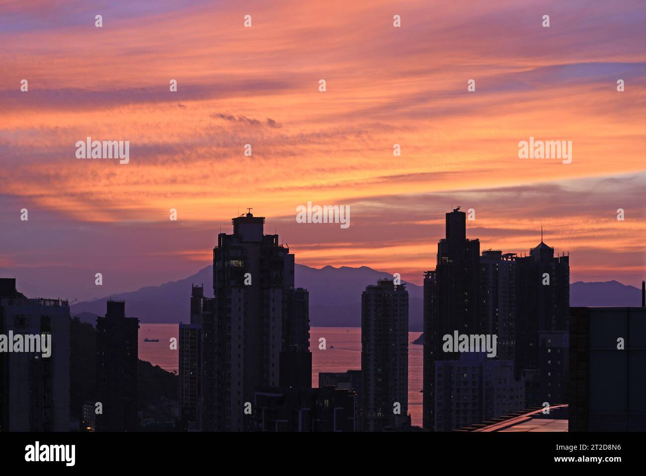 Stadtbild von Hong Kong, Lage in Sheung Wan mit einem Teil des Victoria Harbour während des Sonnenuntergangs und Nachleuchtens Stockfoto