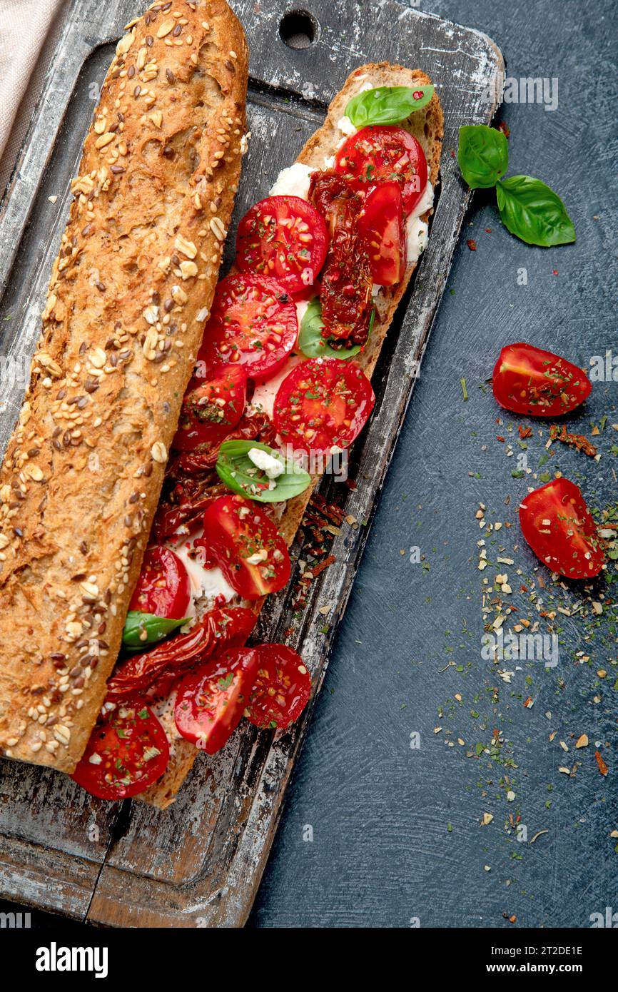 Frisches Baguette mit Caprese. Köstliches Sandwich mit Tomaten und Mozzarella mit frischen Basilikumblättern. Italienisches Essen. Draufsicht. Stockfoto