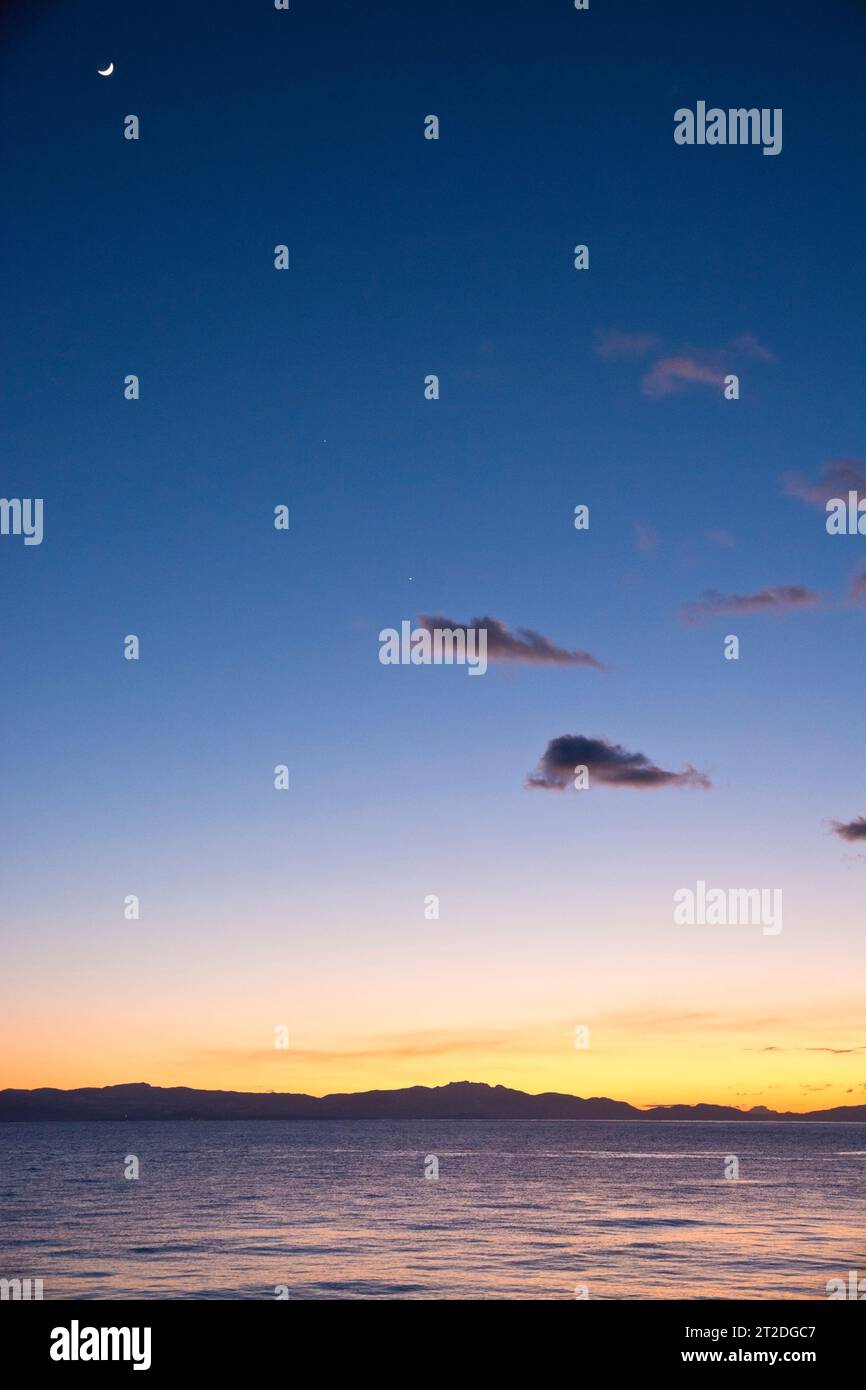 Wintersonnenuntergang über Davis Bay an der Sunshine Coast mit dem Mond im dunklen Himmel. Stockfoto