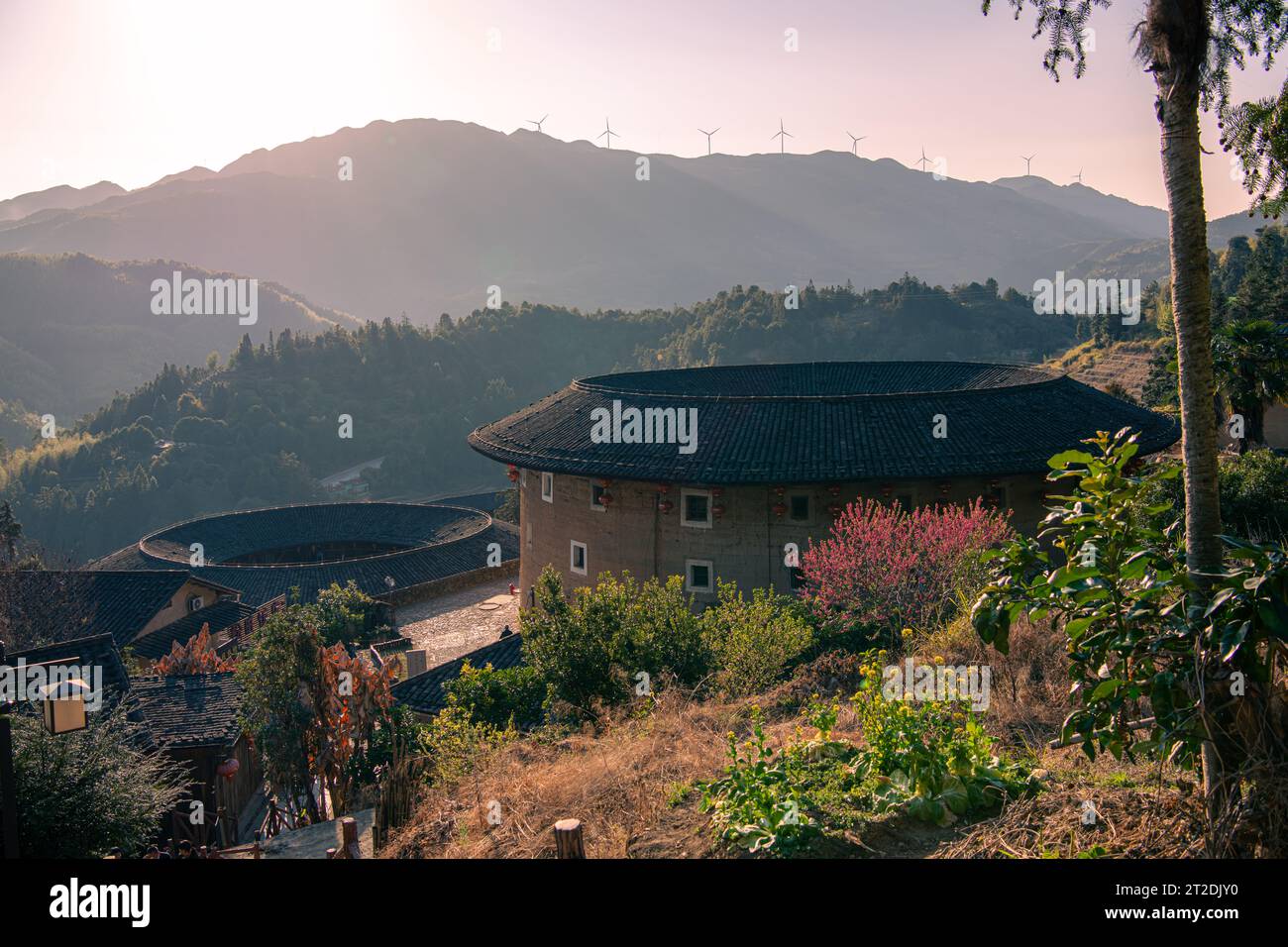 Chinesisches Fujian Tulou und die umliegende Landschaft während des Sonnenuntergangs. Es wurde zum UNESCO-Weltkulturerbe erklärt. Ein berühmtes historisches Relikt. Stockfoto Chinesisches Fujian Tulou und die umliegende Landschaft während des Sonnenuntergangs. Es wurde zum UNESCO-Weltkulturerbe erklärt. Ein berühmtes historisches Relikt. Stockfoto