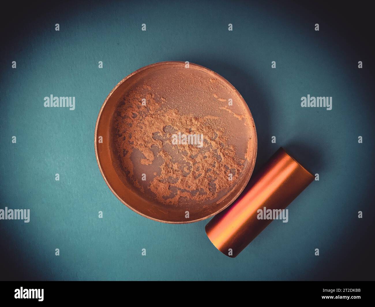 Wunderschöne, modische Kosmetik, glamouröser Becher mit Puder zum Auftragen von Make-up auf das Gesicht auf einem blauen, sanften Hintergrund. Stockfoto