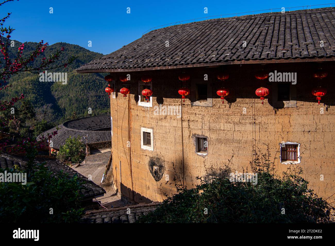 Nahaufnahme des Tulou-Gebäudes im Tianluokeng Tulou Cluster, Fujian, China. Blauer Himmel, traditionelle chinesische Laternen Stockfoto Nahaufnahme des Tulou-Gebäudes im Tianluokeng Tulou Cluster, Fujian, China. Blauer Himmel, traditionelle chinesische Laternen Stockfoto
