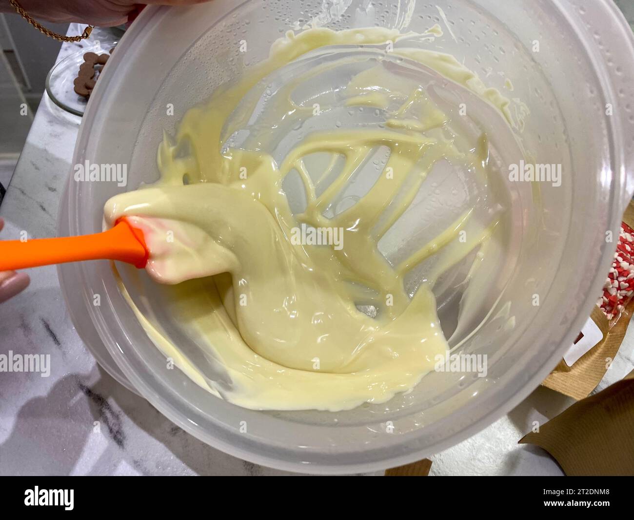 Geschmolzene heiße, weiße, leckere, süße, runde Schokoladenkolben aus belgischer Milchschokolade zum Temperieren und Zubereiten hausgemachter süßer Desserts und Garn Stockfoto