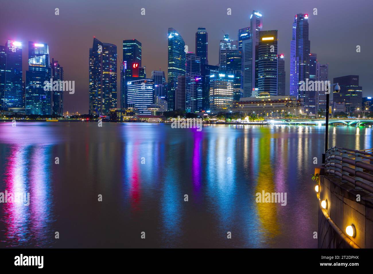 Ein nächtlicher Blick auf die Marina Bay und die Skyline der Stadt in Singapur, von der Promenade des Esplanade Theatre Precinct aus gesehen. Stockfoto