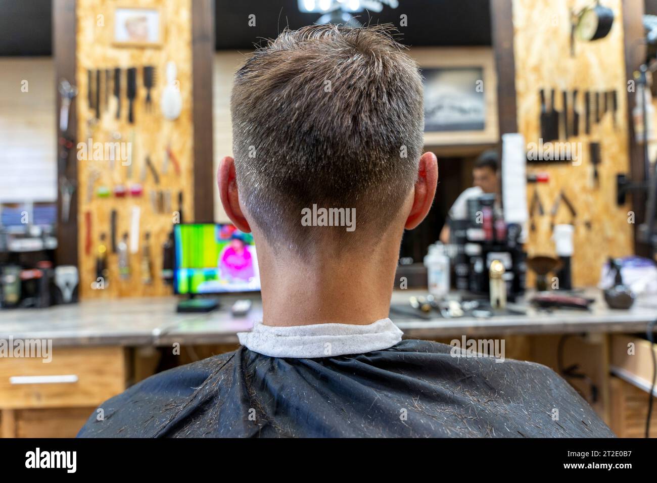 Ein professioneller Friseur schneidet einem Mann die Haare. Besuch im Friseurladen. Haarschneiden für den Kunden. Frisuren in einem Schönheitssalon. hai für Herren Stockfoto