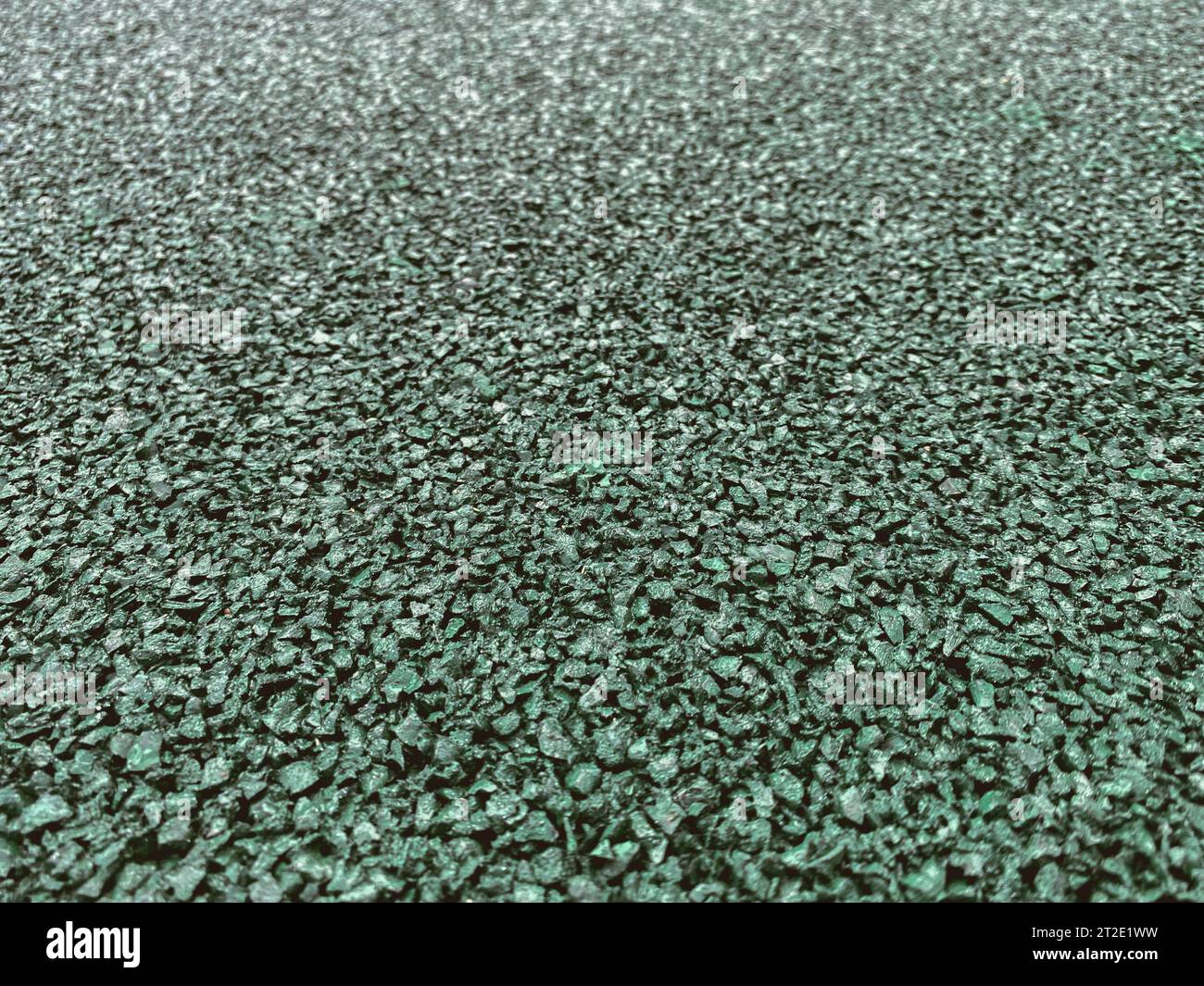 Textur, Hintergrund. Beschichtung für ein Sportfeld aus gummiertem Material in grüner, smaragdgrüner Farbe. Rutschfeste Lauffläche. Stockfoto