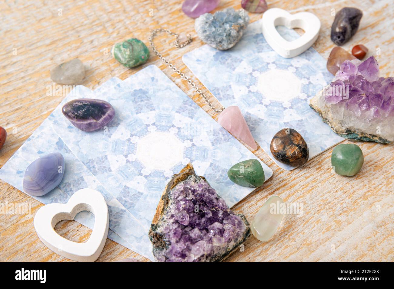 Deck mit handgefertigten Glücksschreiber-Engelskarten auf hellem Holztisch, umgeben von Halbedelsteinen Kristallen zur Dekoration. Stockfoto