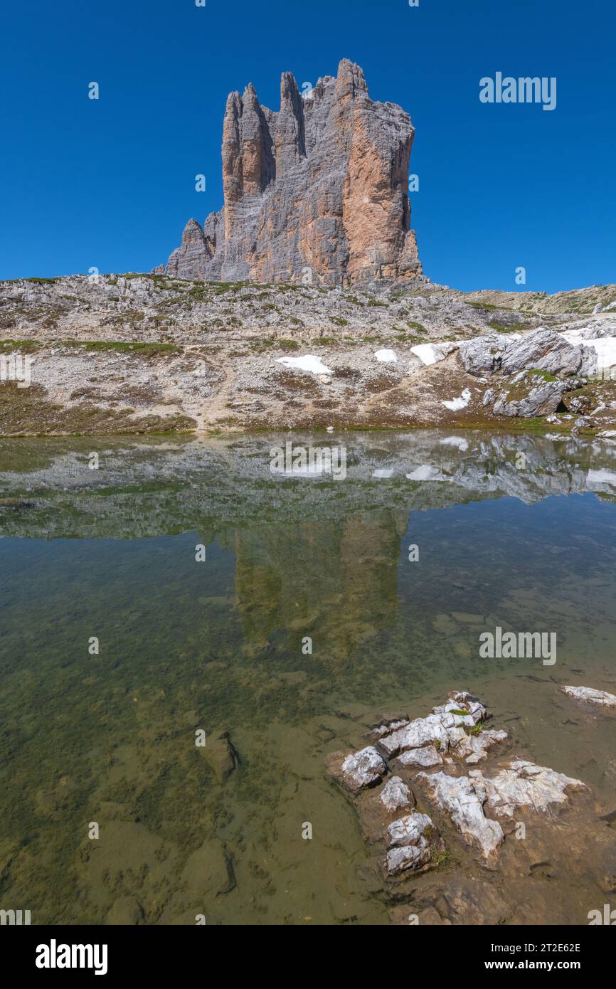 Ostwand der 3 Cime di Lavaredo im Herzen der italienischen Dolomiten. Erodierter Kalkstein reflektiert im noch alpinen Teich Stockfoto