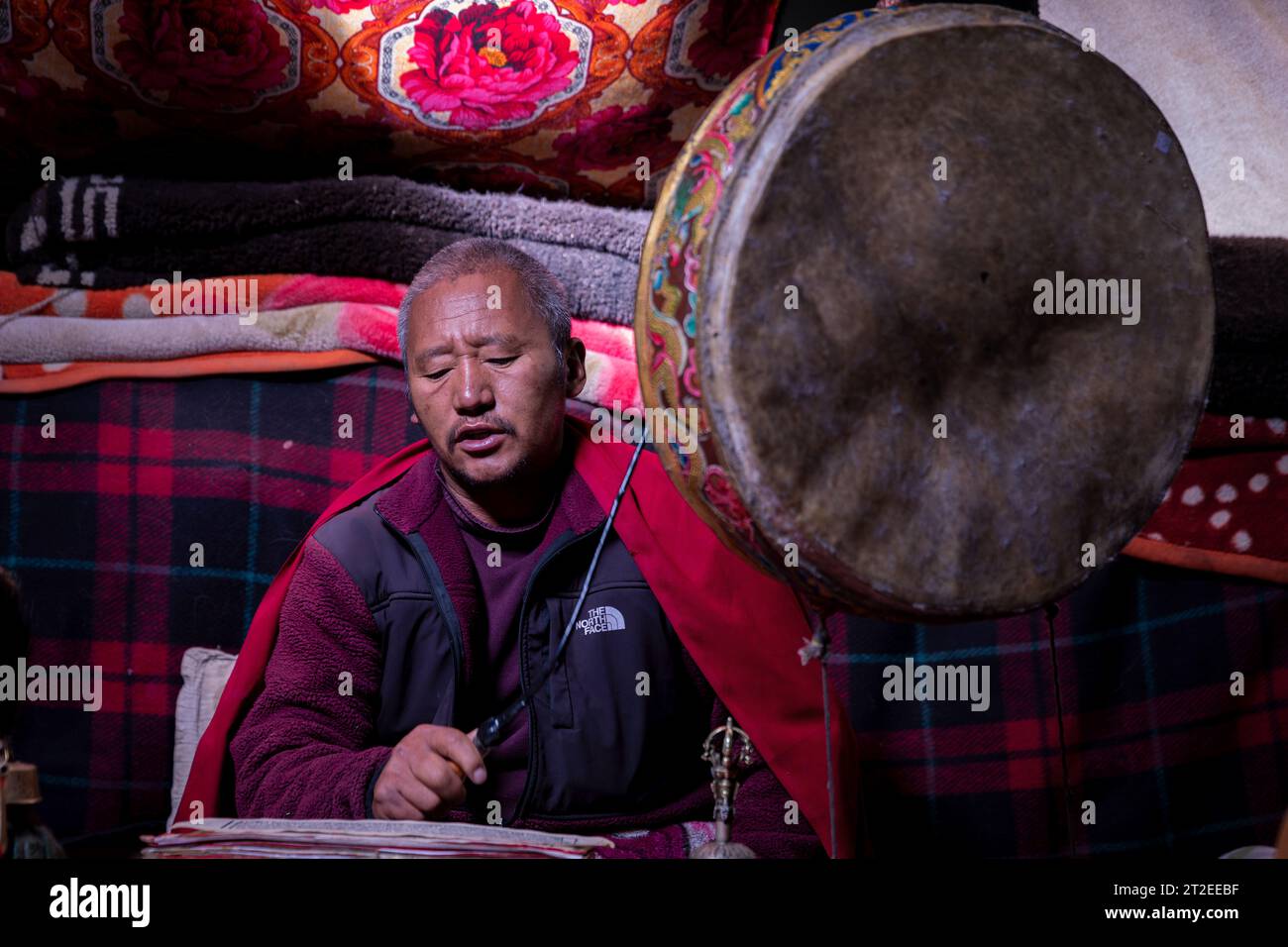 Buddhistischer Mönch spielt Puja in einem Nomadenzelt in Ladakh, Indien Stockfoto