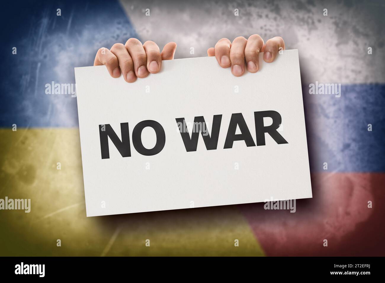 Konzept des Protestes gegen den Krieg zwischen Russland und der Ukraine mit Händen, die ein Schild mit Text und Fahnen hinter sich halten. Stockfoto