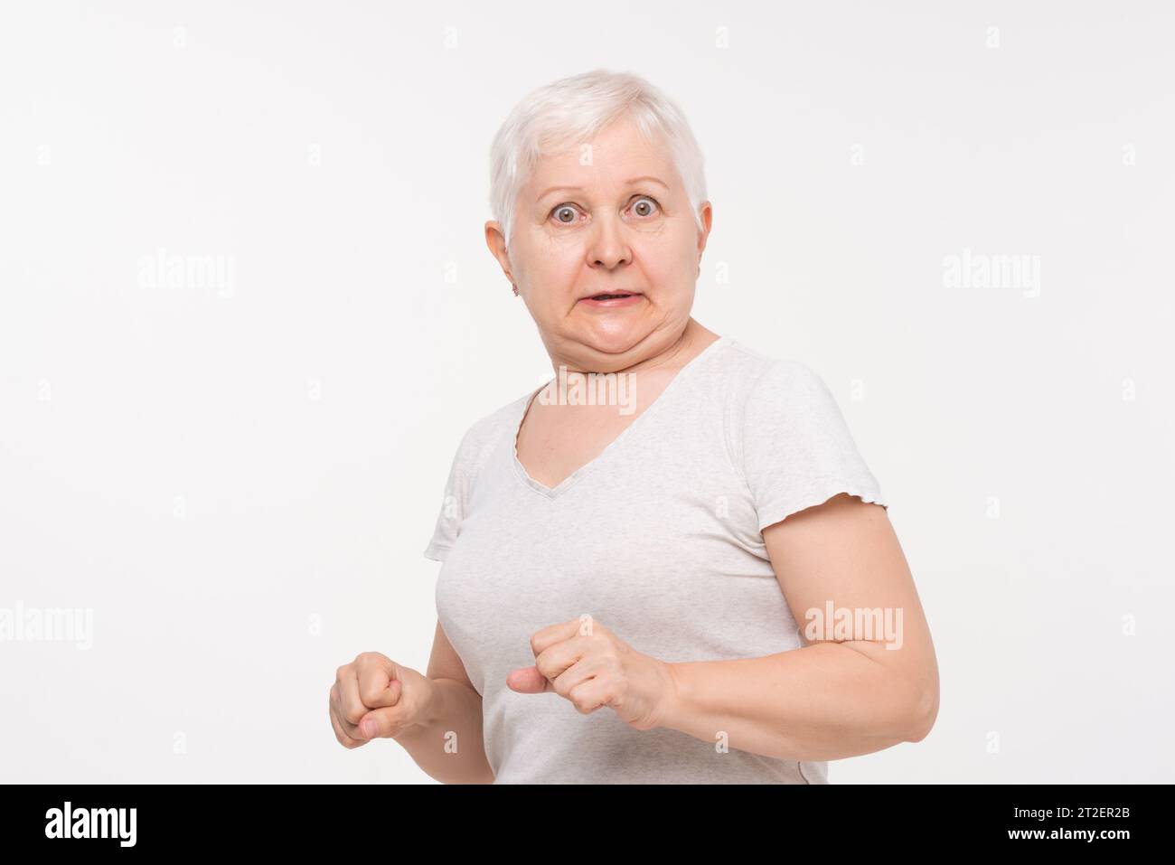 Ältere ältere kaukasische Frau, die schockiert und ängstlich ausdrückt Studio, aufgenommen in weißem isolierten Hintergrund Stockfoto