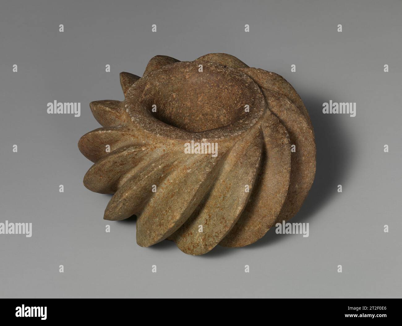 MACE Head Salinar Artist(s) 500–100 v. Chr. dieser gemeißelte Stein-Kegelkopf mit diagonalen Flöten gehört zu den anmutigsten Waffen, die aus den frühesten Kulturen Perus überlebt wurden. Die eleganten, fein geschnitzten, wirbelnden Grate unter der Lippe verleihen dieser Waffe einen fließenden Charakter, die ihren Zweck verleugnet: Die Knochen des Gegners zu zerschlagen oder zu splittern. Diese Grate erhöhen die Effektivität der Waffe, da sich die gesamte Kraft bei der Anwendung auf die schmalen Kanten des Kegelkopfes konzentriert, anstatt sich über eine breitere Oberfläche zu verteilen, ähnlich der Art und Weise, wie man von einem Stiletto-Fersenhals auf ihn tritt, viel mehr PA ist Stockfoto